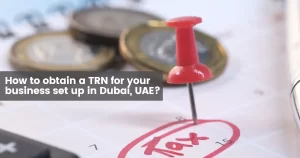 Paper with tax information and assorted coins on a business setup in Dubai office table