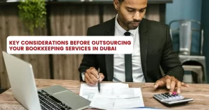 A consultant in bookkeeping services in Dubai checks financial data using a calculator.